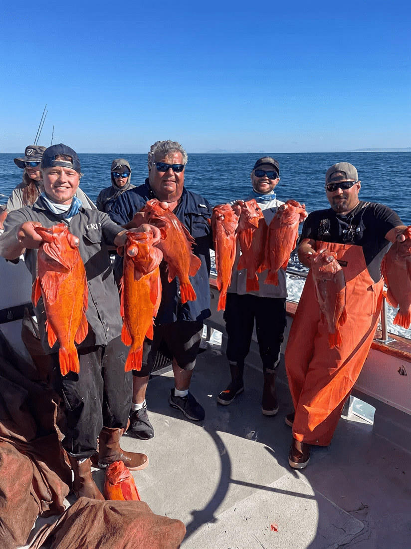 People displaying their fishing catch on boat