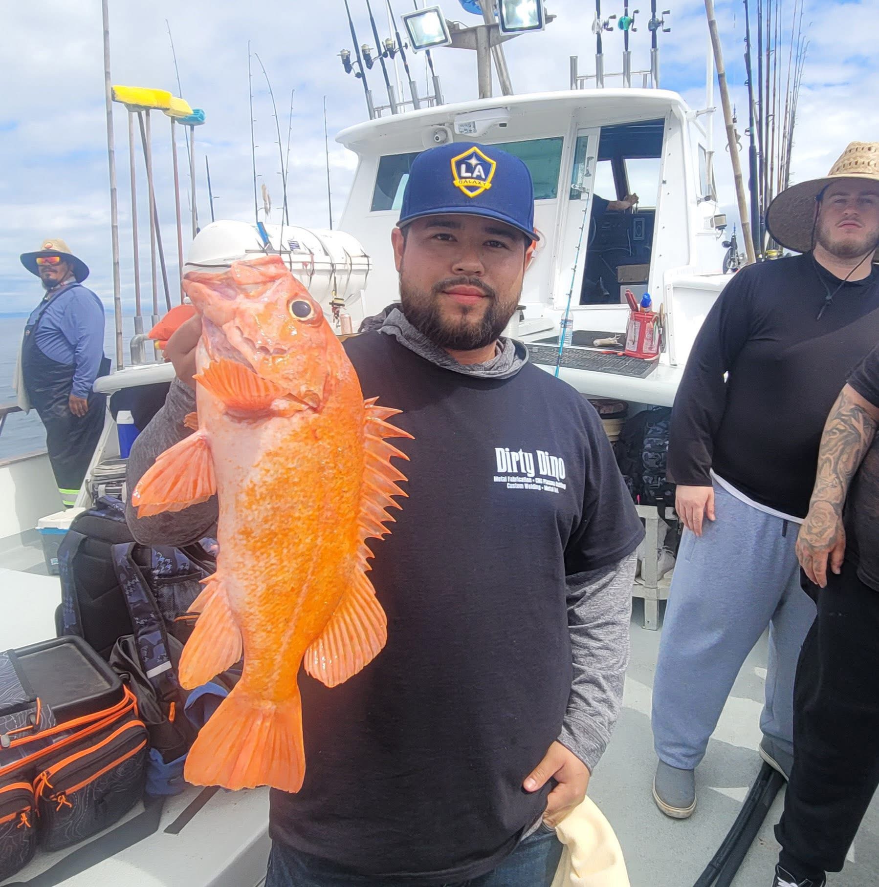 Man holding large orange fish on boat