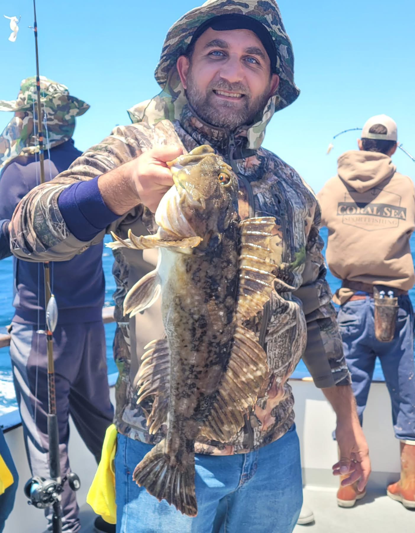Smiling fisherman holding large fish on boat