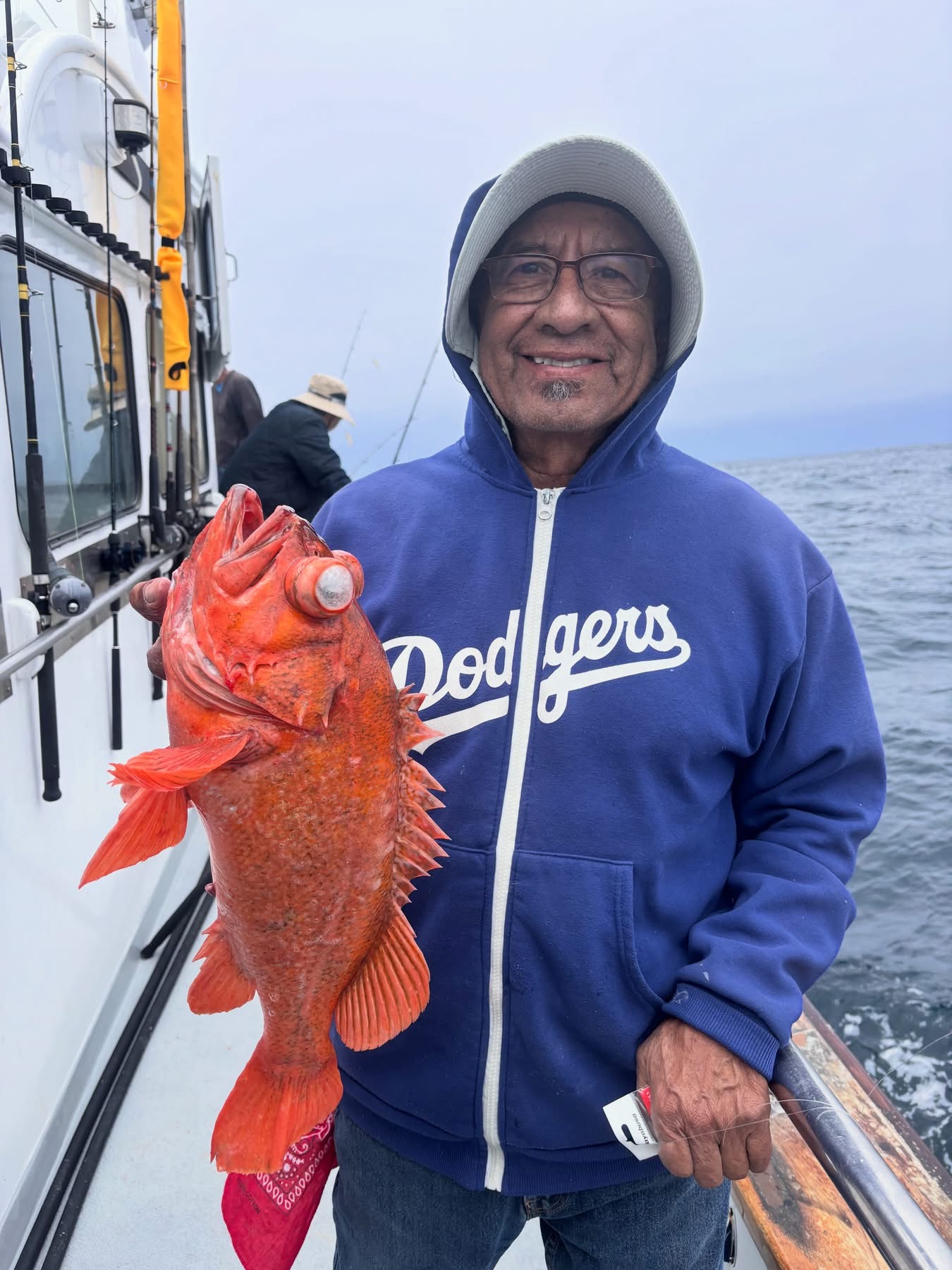 Person holding large red rockfish on boat