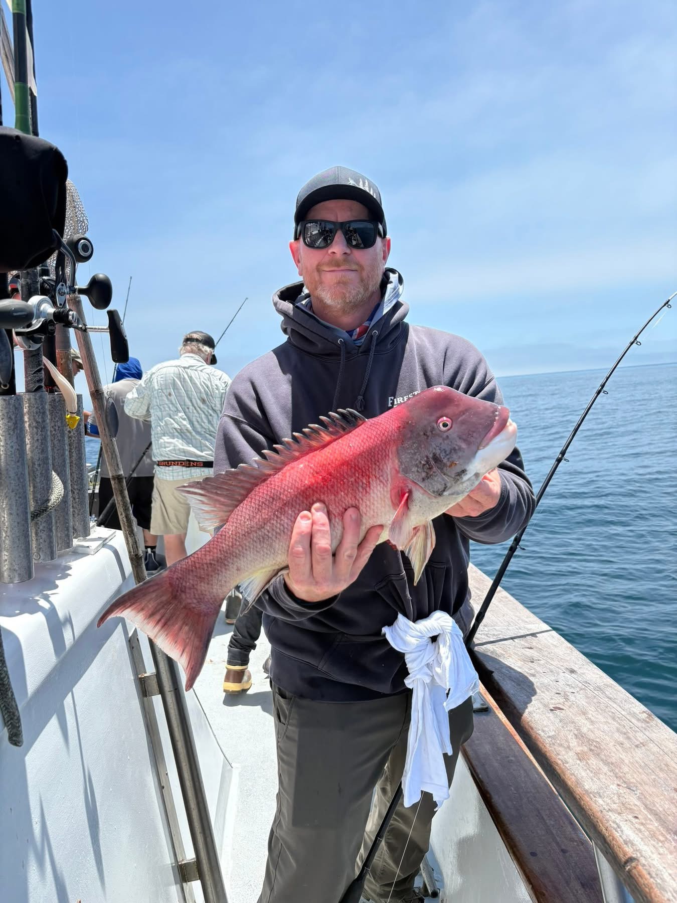 Angler holding large red fish on boat