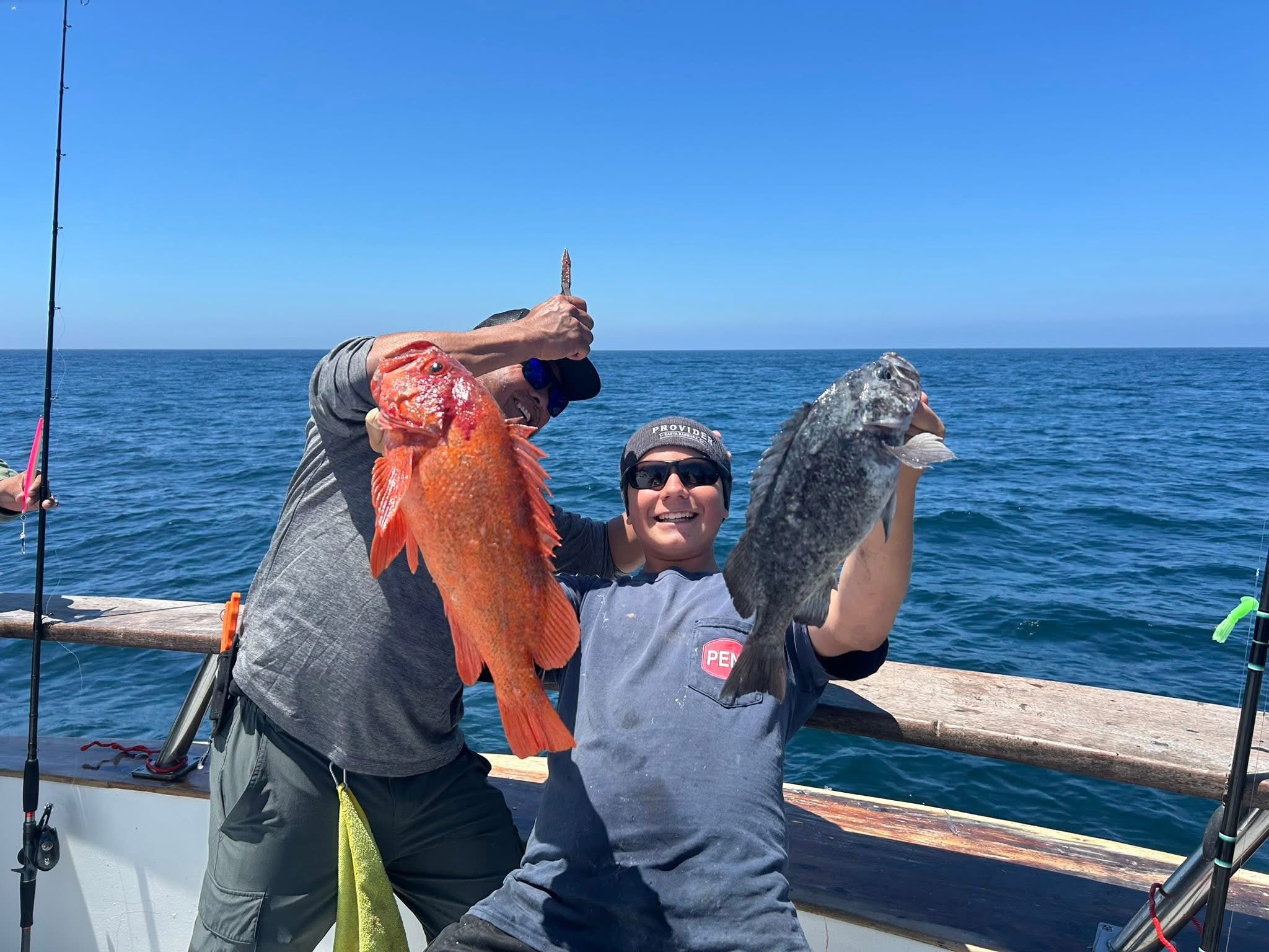 Two people on boat holding large fish